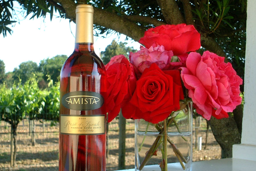 Amista Vineyards bottle of Rose wine with bouquet of roses with vines in the background